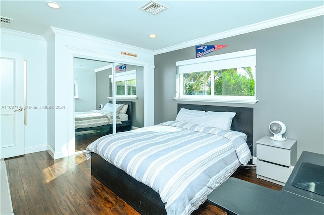 bedroom featuring ornamental molding, dark hardwood / wood-style flooring, and a closet