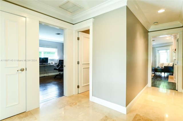 hall featuring plenty of natural light, light wood-type flooring, and ornamental molding