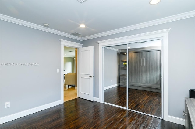 unfurnished bedroom with a closet, dark hardwood / wood-style flooring, and ornamental molding