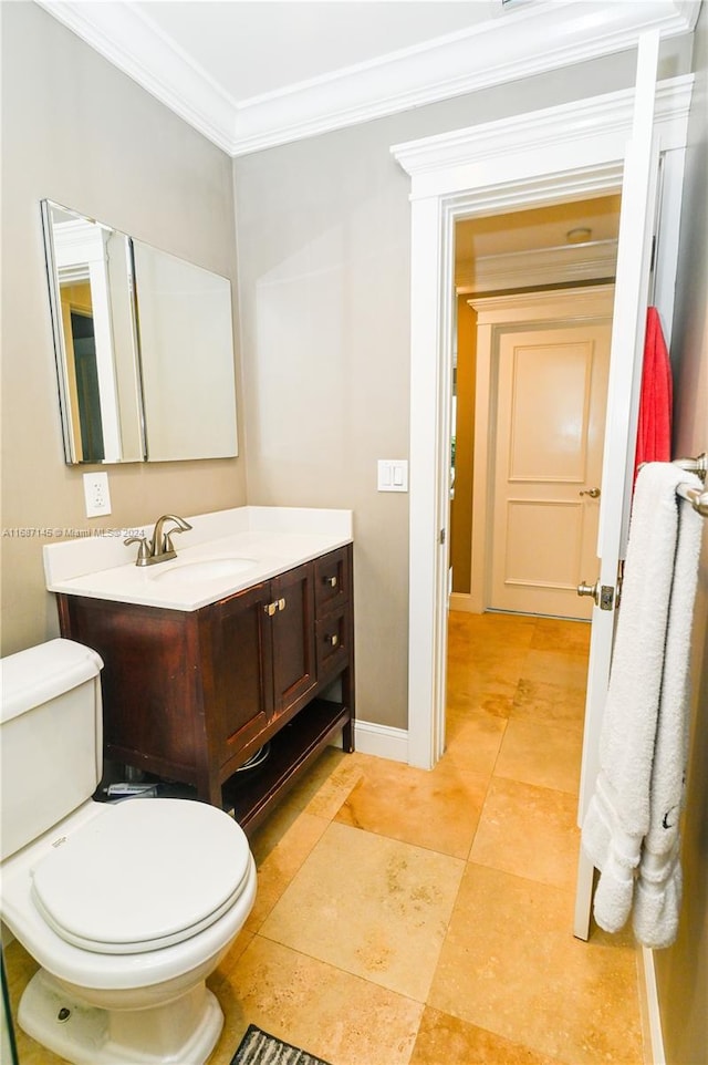 bathroom with toilet, vanity, and crown molding