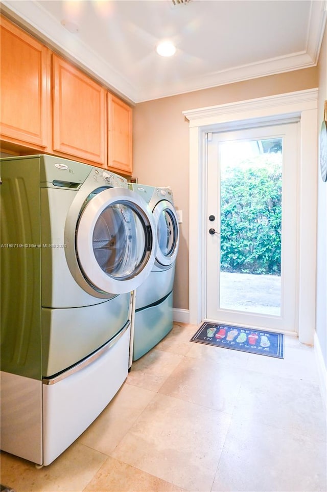 clothes washing area with cabinets, a wealth of natural light, washer and dryer, and ornamental molding