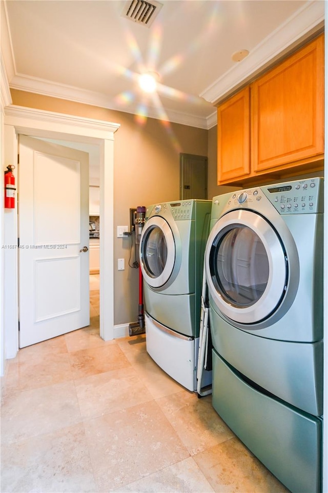 washroom featuring cabinets, independent washer and dryer, and ornamental molding