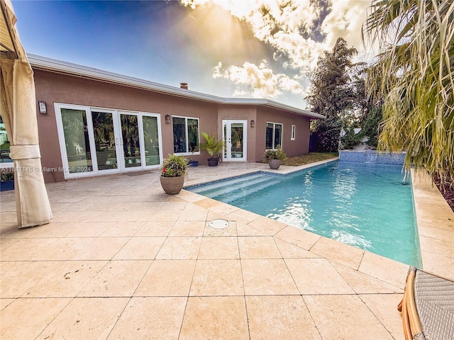 pool at dusk with a patio