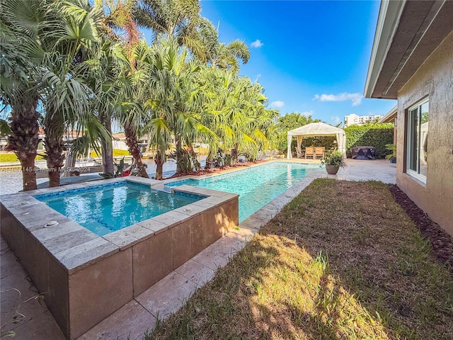 view of pool featuring a patio, a gazebo, and an in ground hot tub