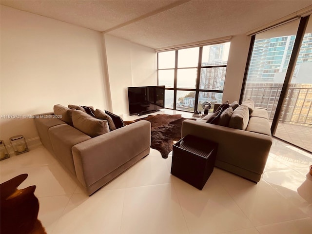 tiled living room featuring floor to ceiling windows and a textured ceiling