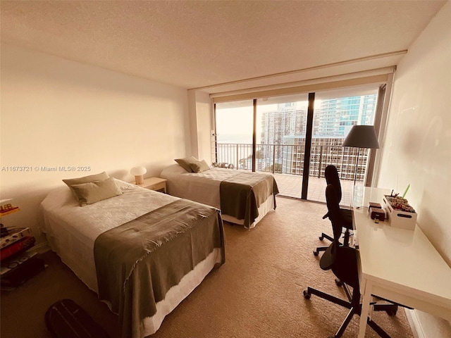 carpeted bedroom featuring access to outside and a textured ceiling