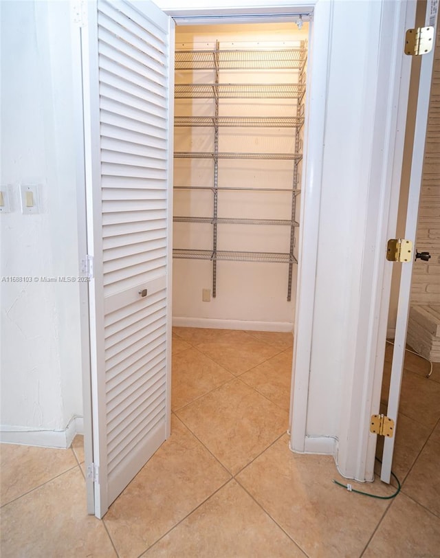 spacious closet with light tile patterned floors