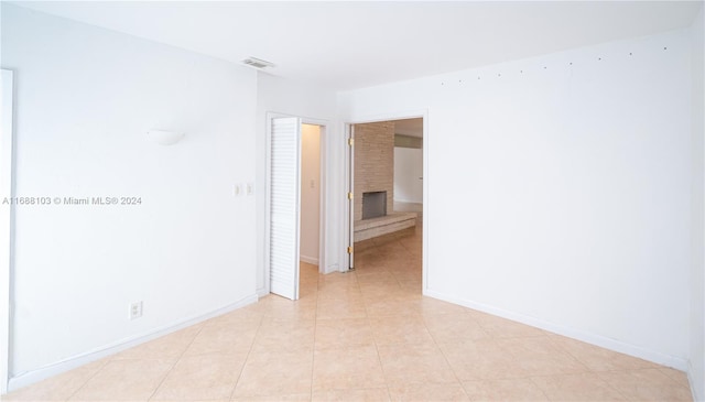 tiled spare room featuring a fireplace