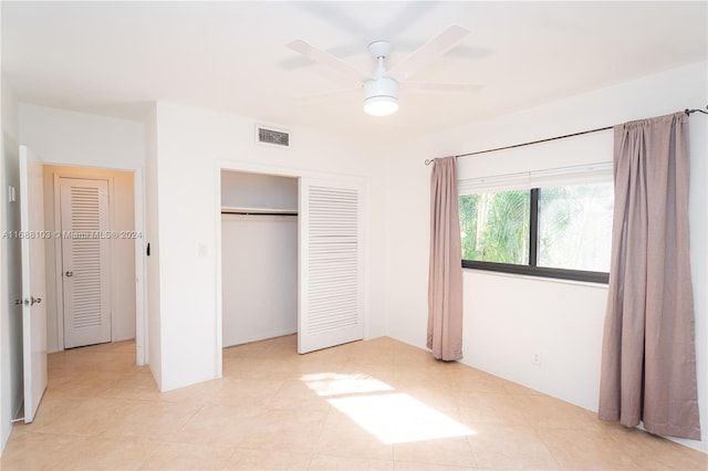 unfurnished bedroom featuring ceiling fan, a closet, and light tile patterned flooring