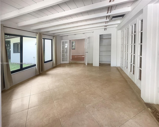 empty room featuring french doors, beamed ceiling, wooden ceiling, and light tile patterned floors