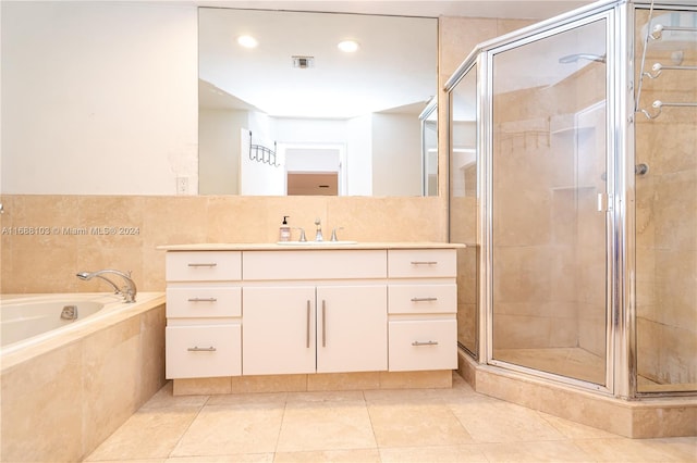 bathroom with vanity, tile patterned flooring, and plus walk in shower