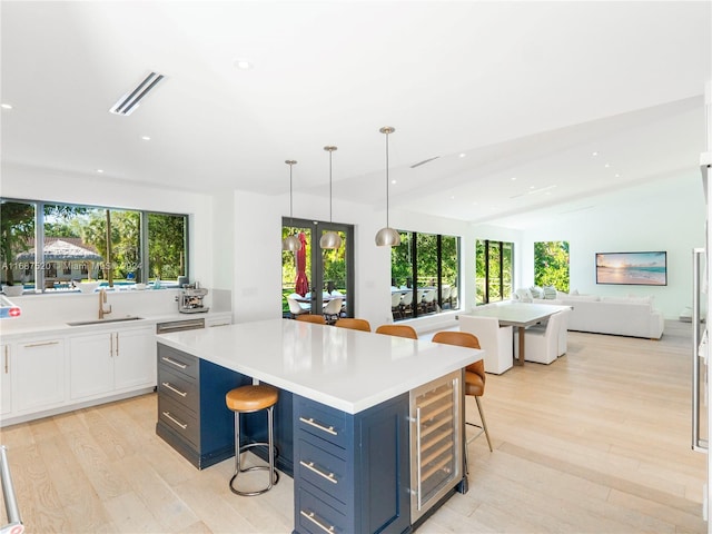 kitchen featuring a kitchen bar, light hardwood / wood-style floors, and hanging light fixtures