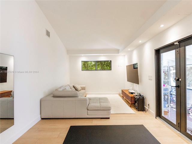 living room with light hardwood / wood-style floors and vaulted ceiling