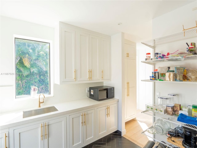 kitchen with white cabinets, dark parquet flooring, and sink