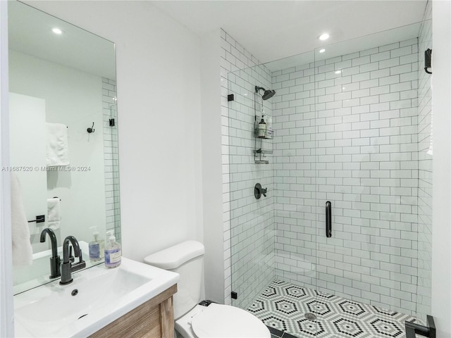 bathroom with toilet, vanity, and a shower with shower door