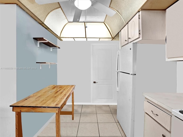 kitchen with white appliances, light tile patterned flooring, ceiling fan, and white cabinets