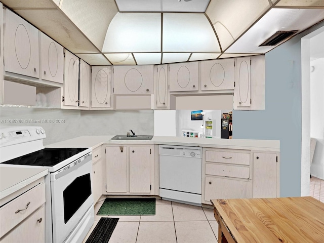 kitchen with light tile patterned floors, white appliances, white cabinets, and sink