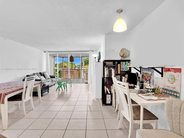 dining room with a textured ceiling, expansive windows, and light tile patterned flooring