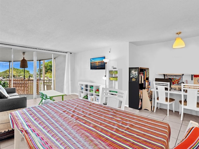 bedroom with a textured ceiling, light tile patterned flooring, and access to exterior