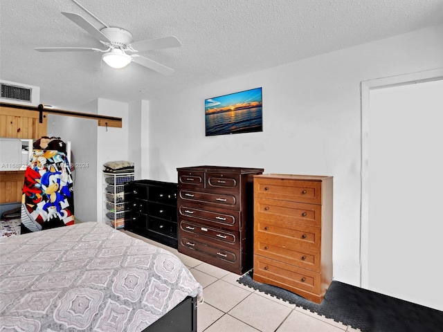 bedroom with ceiling fan, a textured ceiling, and light tile patterned floors