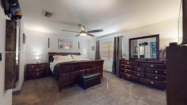 carpeted bedroom with ceiling fan and a textured ceiling