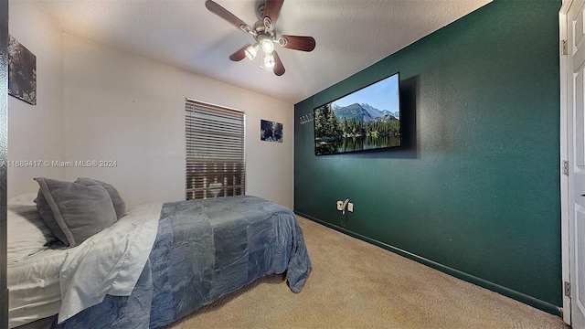 bedroom with a textured ceiling, ceiling fan, and carpet floors