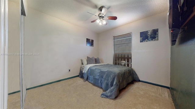 carpeted bedroom with a textured ceiling and ceiling fan