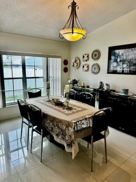 tiled dining area with vaulted ceiling and a textured ceiling