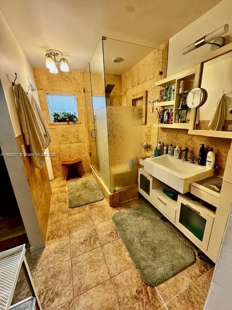 bathroom with tile patterned flooring, vanity, and an enclosed shower