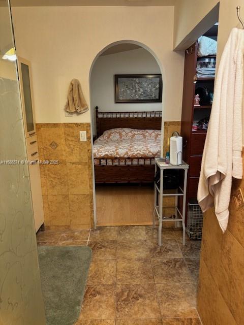 bedroom featuring tile walls