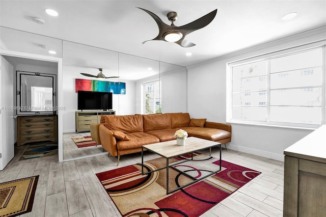 living room with ceiling fan and crown molding