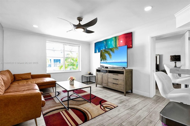 living room featuring ornamental molding, light wood-type flooring, and ceiling fan