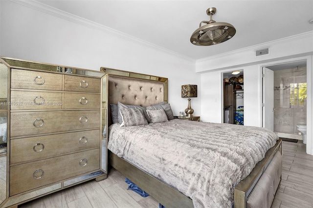 bedroom with ornamental molding, a spacious closet, and ensuite bath