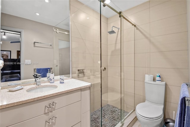 bathroom featuring vanity, toilet, and a shower with shower door