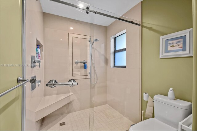 bathroom featuring toilet and an enclosed shower