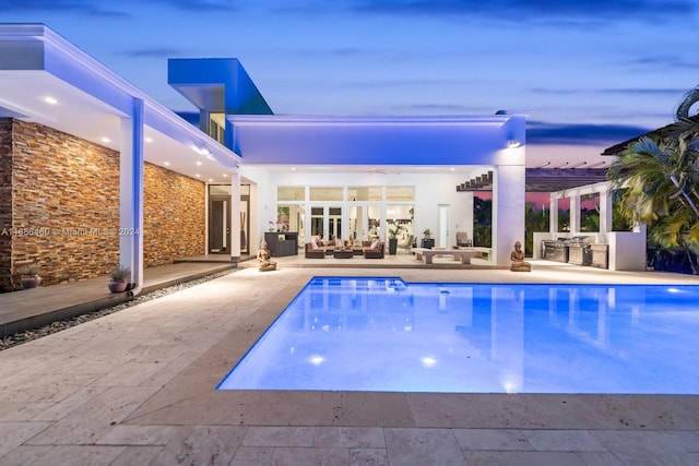 pool at dusk with a patio and a pergola