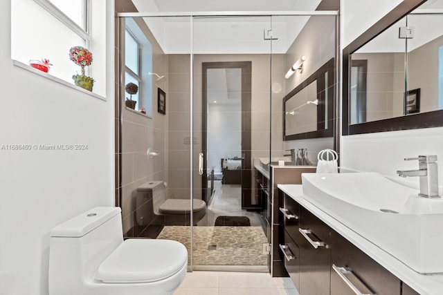 bathroom with toilet, vanity, tile patterned flooring, and walk in shower