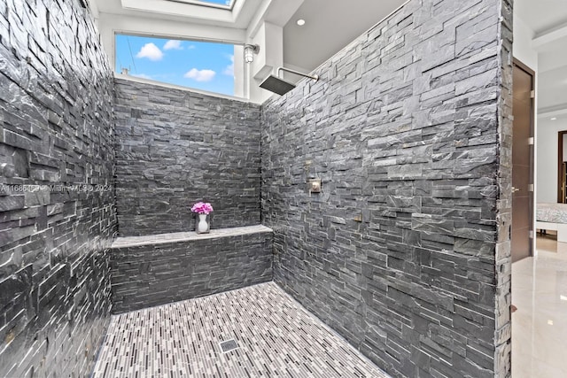 bathroom featuring walk in shower and a skylight