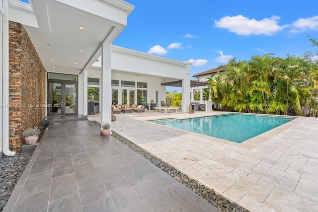 view of pool with a patio, french doors, and ceiling fan