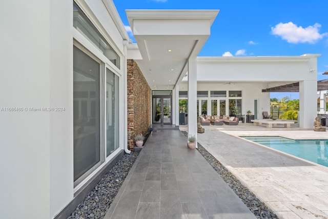 view of pool featuring a patio, an outdoor living space, and ceiling fan