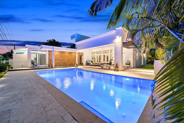 pool at dusk with a patio