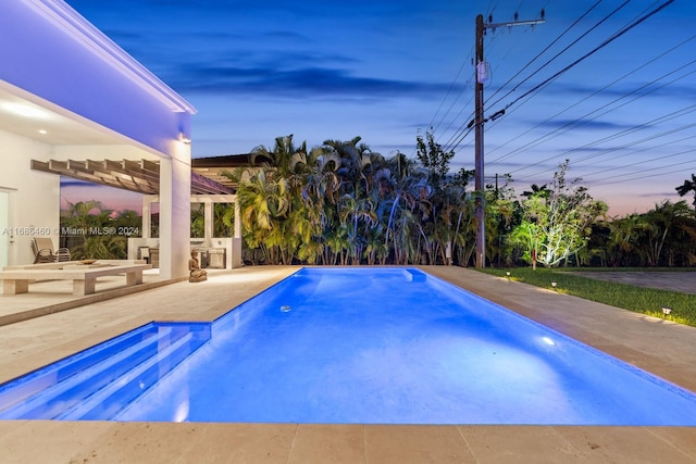 pool at dusk with a patio