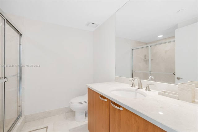 bathroom with toilet, vanity, tile patterned floors, and a shower with shower door