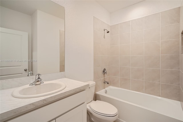 full bathroom with toilet, tiled shower / bath combo, and vanity