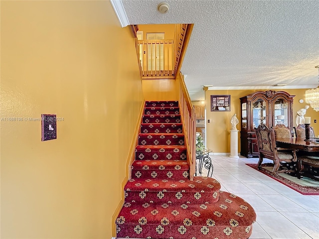 staircase featuring an inviting chandelier, tile patterned floors, a textured ceiling, and crown molding