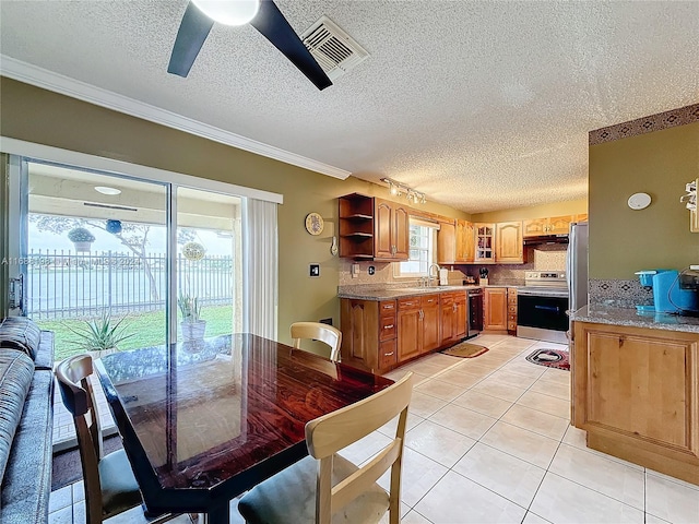 dining area with sink, ornamental molding, ceiling fan, a textured ceiling, and light tile patterned floors