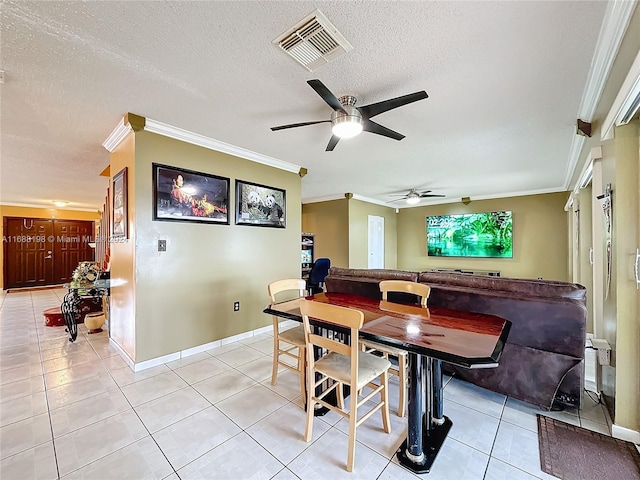 dining room with light tile patterned flooring, a textured ceiling, and crown molding