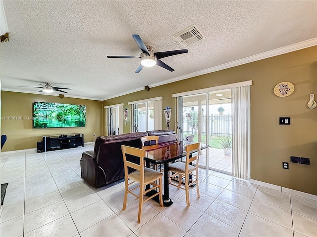 tiled dining room with ceiling fan, a textured ceiling, and ornamental molding