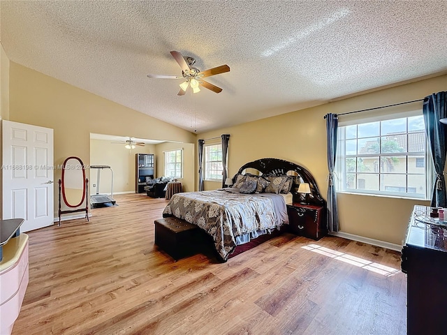 bedroom featuring a textured ceiling, light hardwood / wood-style flooring, ceiling fan, and vaulted ceiling