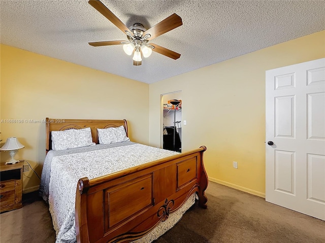 carpeted bedroom featuring a textured ceiling, ceiling fan, a walk in closet, and a closet